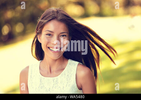 Certi giovani asiatici bellezza cinese donna sorridente. Bel ritratto di sani di sesso femminile in adulti estivo soleggiato parco erba sfondo per la primavera, estate o allergia da polline stagione concetto. Foto Stock