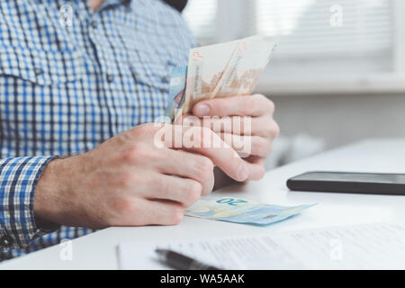 Imprenditore calcola le spese sostenute o stipendio. Foto Stock