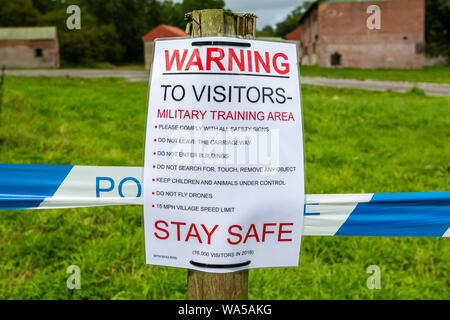 Visitatore segno di avvertimento di pericolo nel villaggio fantasma di Imber, Wiltshire, Regno Unito il 17 agosto 2019 Foto Stock