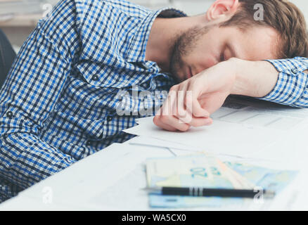 Affaticati e stanchi lavoratore di ufficio dormire oltre al lavoro sul tavolo in ufficio Foto Stock