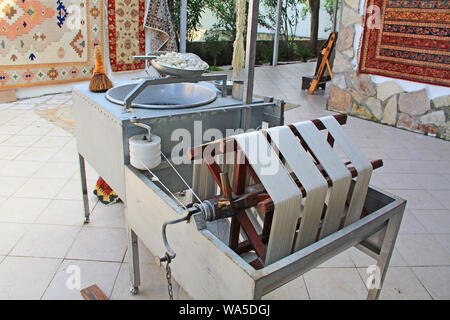 Ruota di filatura e di altre apparecchiature per la separazione di sottili fili di seta da bozzoli in un kibbutz in Turchia vicino a Selcuk. Foto Stock