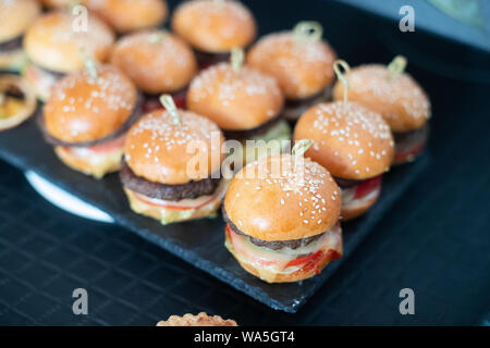 Hamburger sul tavolo. Poco hamburger su un vassoio. Concetto di cibo. Foto Stock