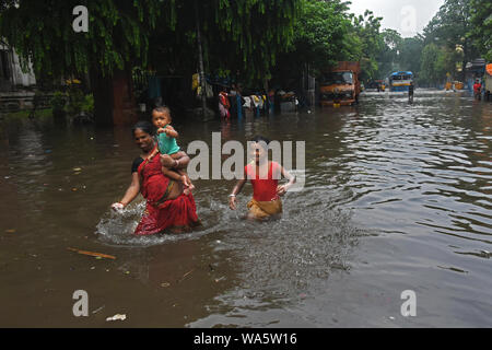 Kolkata, India. 17 Ago, 2019. Una donna locale sta andando a rifugiarsi con il suo bambino. (Foto di Suraranjan Nandi/Pacific Stampa) Credito: Pacific Press Agency/Alamy Live News Foto Stock