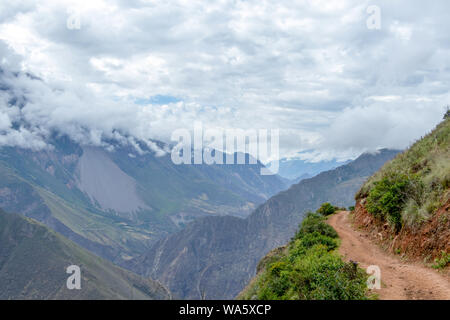 Percorso trekking ad alta quota montagne peruviane, verdi pendii ripidi di Apurimac River Valley con picchi coperto di nuvole, il Senso - Inka trek per Foto Stock