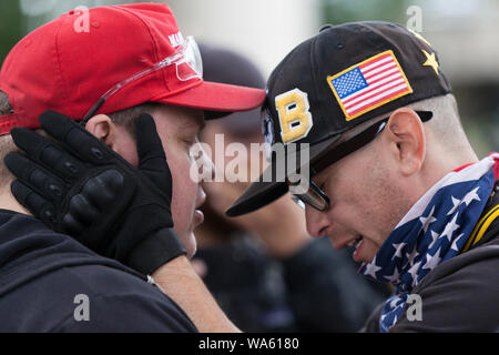 Due uomini in pausa per una preghiera durante la "fine del terrorismo interno" al rally di Tom McCall Waterfront Park il 17 agosto 2019 a Portland, Oregon. Organizzato come una manifestazione di protesta contro l'anti-fascisti da destra host radio Joe Biggs e membri dell'orgoglioso Boys, il rally ha attratto un grande contingente di counterprotesters comprese Città Rosa Antifa. Foto Stock