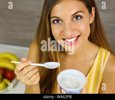 Giovane donna luce mangiare lo yogurt greco a casa. Chiudere dall'alto. Un sano concetto. Foto Stock