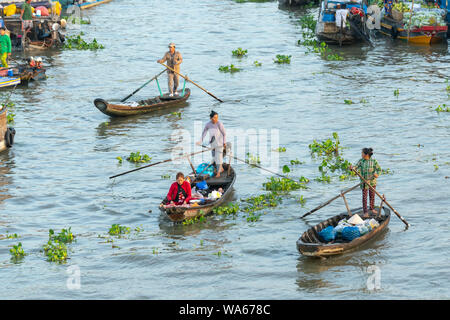 Traghetto di canottaggio donna porta i visitatori o i prodotti agricoli sul fiume mercato galleggiante , questo è il trasporto principale il nuovo anno lunare in Soc Trang, Foto Stock