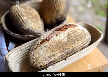 Pane appena sfornato dal forno a legna giacente in cesti di raffreddarsi Foto Stock