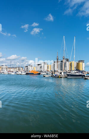 Waterside apartments e ormeggiate barche a vela Sovereign Harbour, Eastbourne, East Sussex, England, Regno Unito Foto Stock