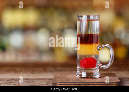 Un cocktail Chekhov sulla base di gin e martini rosso, un multi-layered bevande si erge sullo sfondo del bar, un luogo per il testo Foto Stock