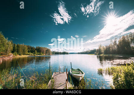 Vecchio di legno barca da pesca ormeggiate vicino molo In Estate Lago o fiume. Estate bella giornata di sole o la sera. La natura svedese. Arjang SV, Tocksfors, Svezia. Foto Stock