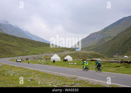 (190818) -- URUMQI, Agosto 18, 2019 (Xinhua) -- appassionati di ciclismo corsa sulla Dushanzi-Kuqa autostrada, a nord-ovest della Cina di Xinjiang Uygur Regione autonoma, Agosto 17, 2019. La sezione Dushanzi-Kuqa della Strada Nazionale 217 corre attraverso vari di paesaggi naturali tra cui ghiacciai, laghi, boschi e praterie, che la rendono un popolare percorso di marcia tra auto-guida viaggiatori, gli amanti della bicicletta e delle escursioni. (Xinhua/Li Peng) Foto Stock