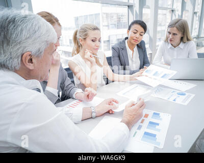 Un gruppo di uomini di affari che discutere di diagrammi in Office insieme Foto Stock