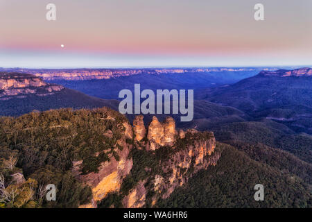 Famoso monumento naturale nelle Blue Mountains of Australia - la formazione rocciosa Tre Sorelle al tramonto sotto il cielo rosa. Foto Stock