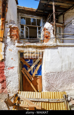 Capanna abbandonata casa con sbarrata la porta chiusa e il vetro rotto vetro in hamamonu, Ankara, Turchia Foto Stock