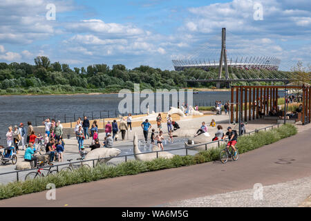 Varsavia, Polonia, 14 Luglio: persone relax al fiume Vistola viali con ponte Swietokrzyski e Stadio nazionale all'estremità lontana. Foto Stock