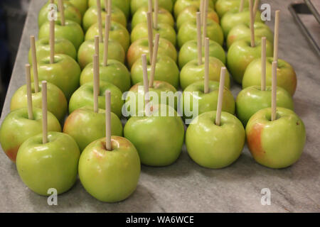 mele verdi fresche con bastoncini pronti per essere immerse rivestimento caramello o caramello Foto Stock