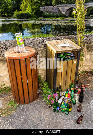 Riverside bidoni della spazzatura traboccante di birra e di vino Bottiglie - Vienne, in Francia. Foto Stock