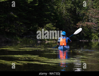 Un uomo che ottiene una vista da un kayak su una pagaia di mattina Foto Stock