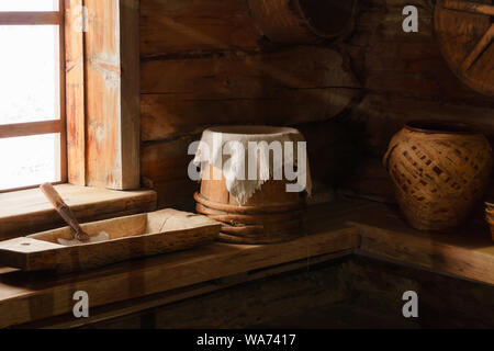 Frammento della parte interna di un vecchio contadino log cabin - Banchi con pavimenti in legno e ceramica per utensili Foto Stock