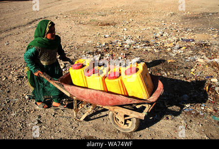 (190818) -- JALALABAD, Agosto 18, 2019 (Xinhua) -- Un bambino afghano porta barili dopo il recupero di acqua da un pubblico pompa ad acqua a un campo di sfollati nel distretto di Rodat di Nangarhar, Afghanistan, Agosto 17, 2019. (Foto di Saifurahman Safi/Xinhua) Foto Stock