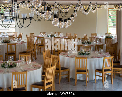 Set di tabelle per matrimonio sotto luce decorazioni Foto Stock