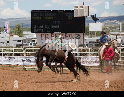 Un cowpoke non resta molto tempo a bordo di questo strappi bronco in corrispondenza di una grande piscina rodeo che è una funzione dell'annuale (in questo caso settantacinquesimo anniversario) Giubileo festival A Laramie, Wyoming Foto Stock