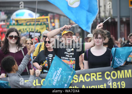 Manchester, Regno Unito. Il 18 agosto, 2019. Oltre mille persone hanno marciato e frequentando un rally per la democrazia in concomitanza con la commemorazione del massacro di Peterloo, quando il 16 agosto 1819 una folla di 60.000 camminato al punto di incontro nella Basilica di San Pietro in Campo quando le forze del governo in carica la folla, uccidendo 18 uomini, donne e bambini e ferendo centinaia. 200 anni più tardi e la città ricorda. Lavoro sospeso MP Chris Williamson è stato acclamato e applaudito come egli ha parlato al rally in piazza Albert, Manchester, Regno Unito. Credito: Barbara Cook/Alamy Live News Foto Stock