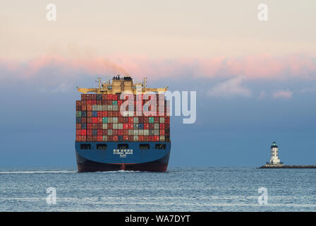 Nave portacontainer Hyundai in partenza dal porto di Los Angeles al tramonto. Sulla destra si trova il Los Angeles Harbor Light. Foto Stock