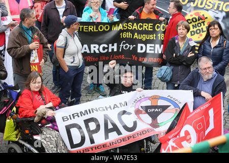 Manchester, Regno Unito. Il 18 agosto, 2019. Oltre mille persone hanno marciato e frequentando un rally per la democrazia in concomitanza con la commemorazione del massacro di Peterloo, quando il 16 agosto 1819 una folla di 60.000 camminato al punto di incontro nella Basilica di San Pietro in Campo quando le forze del governo in carica la folla, uccidendo 18 uomini, donne e bambini e ferendo centinaia. 200 anni più tardi e la città ricorda. Lavoro sospeso MP Chris Williamson è stato acclamato e applaudito come egli ha parlato al rally in piazza Albert, Manchester, Regno Unito. Credito: Barbara Cook/Alamy Live News Foto Stock