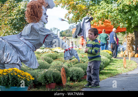 Bridgman Michigan STATI UNITI D'AMERICA, 29 settembre 2017; in corrispondenza di una porta di fattoria di zucca, un ragazzino ha paura di un manichino, e mantenendo la sua distanza Foto Stock