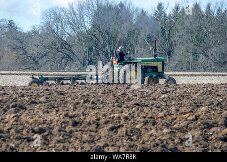 Aprile 28 2018 Buchanan MI USA; il trattore arare un campo di fattoria durante un evento di aratro in America del nord Foto Stock