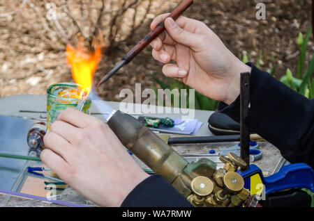 Un'artista utilizza il fuoco e vetro per creare arte Foto Stock