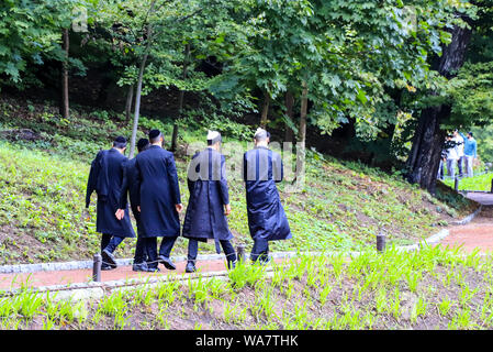 Boys in una famiglia di ebrei Hasidic, nei tradizionali abiti neri a piedi nel parco di Uman, Ucraina, il tempo dell'anno ebraico, religiosa ortodossa Je Foto Stock