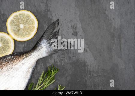 Pesce fresco dorado. Coda Dorados e gli ingredienti per cucinare su un sfondo di calcestruzzo. Foto Stock