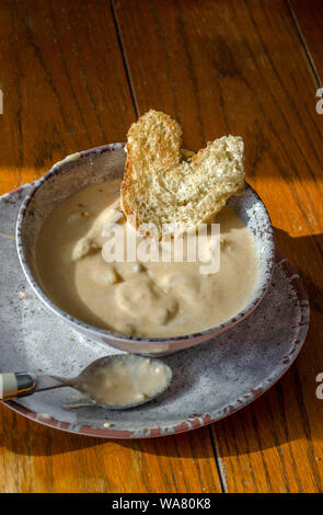 Chunky minestra di patate in una ciotola rustico e la piastra, è sostanziosa comfort food in una fredda giornata invernale e Foto Stock