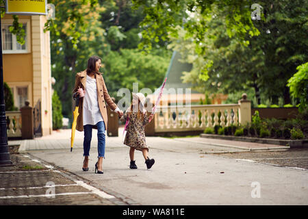 Giovane madre e figlia a piedi dalla scuola Foto Stock