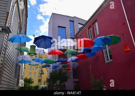 Ombrelloni colorati e lanterne sospese tra due edifici di Bergen, Norvegia. Foto Stock