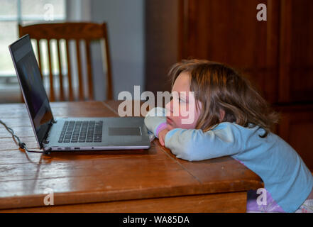 Bambino in pigiama si rilassa a tavola con la nonna laptop, guardando i bambini canzone video Foto Stock