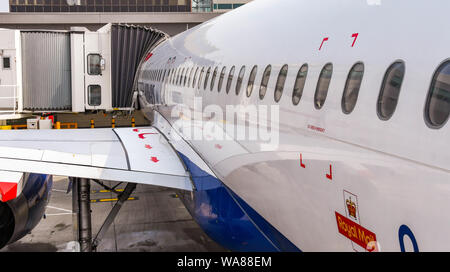 Dall'Aeroporto Gatwick di Londra, Inghilterra - Aprile 2019: lato di un British Airways Airbus jet attaccato ad un passeggero ponte aereo all'Aeroporto di London Gatwick Foto Stock