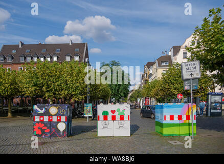 Coloratissimo graffito dipinto su calcestruzzo paracarri blocchi o barriere per proteggere da attacchi terroristici, situato a Burgplatz nella città vecchia di Düsseldorf. Foto Stock