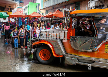 Un Jeepney preleva i passeggeri in Chinatown, Manila, Filippine Foto Stock