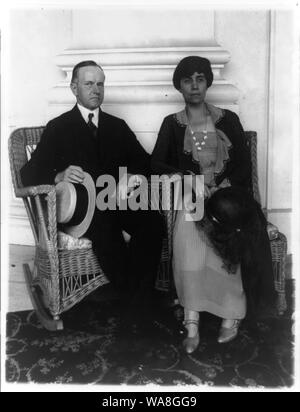 Calvin Coolidge e sua moglie di intera lunghezza verticale, seduti in poltrone in vimini Foto Stock