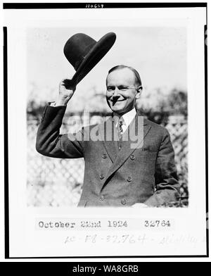 Calvin Coolidge, mezza lunghezza ritratto, in piedi, rivolto verso sinistra, il ribaltamento il suo cappello Foto Stock