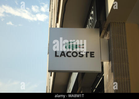 Store segno di Lacoste logo su un vecchio edificio sulla sua facciata in Spagna Foto Stock