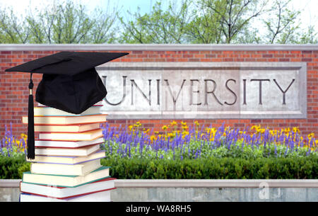 Una pila di libri colorati nella parte anteriore del campus della University Foto Stock