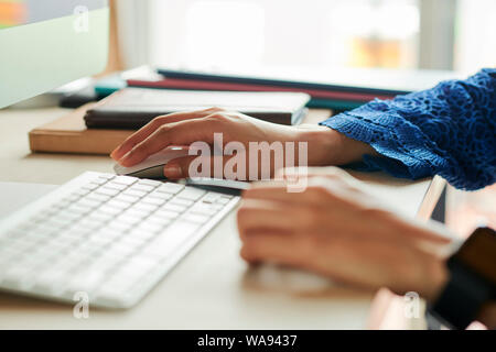 Le mani del giovane imprenditrice lavorando sul computer in ufficio, il fuoco selettivo Foto Stock