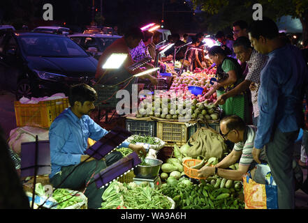 (190819) -- NEW DELHI, 19 Agosto, 2019 (Xinhua) -- persone selezionare le verdure sul mercato di domenica a Nuova Delhi, in India, e il agosto 18, 2019. Molti mercati di notte aperta nei fine settimana di New Delhi, attirando un numero di clienti per i prodotti freschi un prezzo inferiore. (Xinhua/Zhang Naijie) Foto Stock