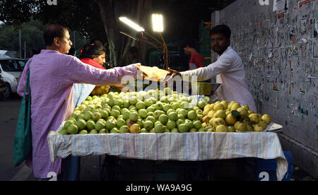 (190819) -- NEW DELHI, 19 Agosto, 2019 (Xinhua) -- persone selezionare di frutta sul mercato di domenica a Nuova Delhi, in India, e il agosto 18, 2019. Molti mercati di notte aperta nei fine settimana di New Delhi, attirando un numero di clienti per i prodotti freschi un prezzo inferiore. (Xinhua/Zhang Naijie) Foto Stock