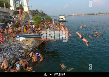 I residenti locali raccogliere e tuffarsi nel fiume Han raffreddare su un bruciante giorno in Xiangyang city, centrale cinese della provincia di Hubei, 22 luglio 2019. Foto Stock